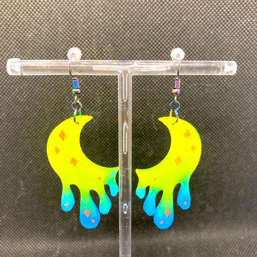 Vibrant moon shaped glow in the dark earrings.